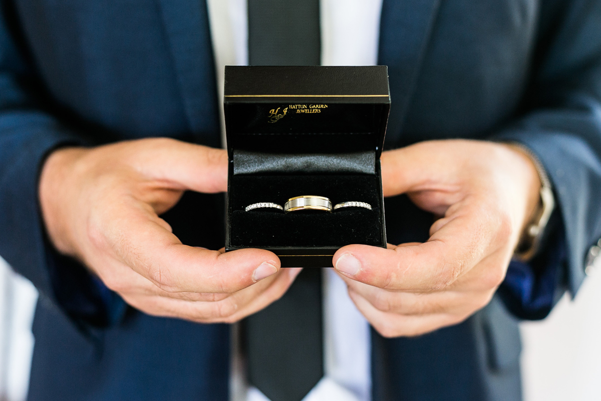 Close up of the wedding bands in their box held by the groom wearing a navy blue suit Tocal Homestead wedding photographer