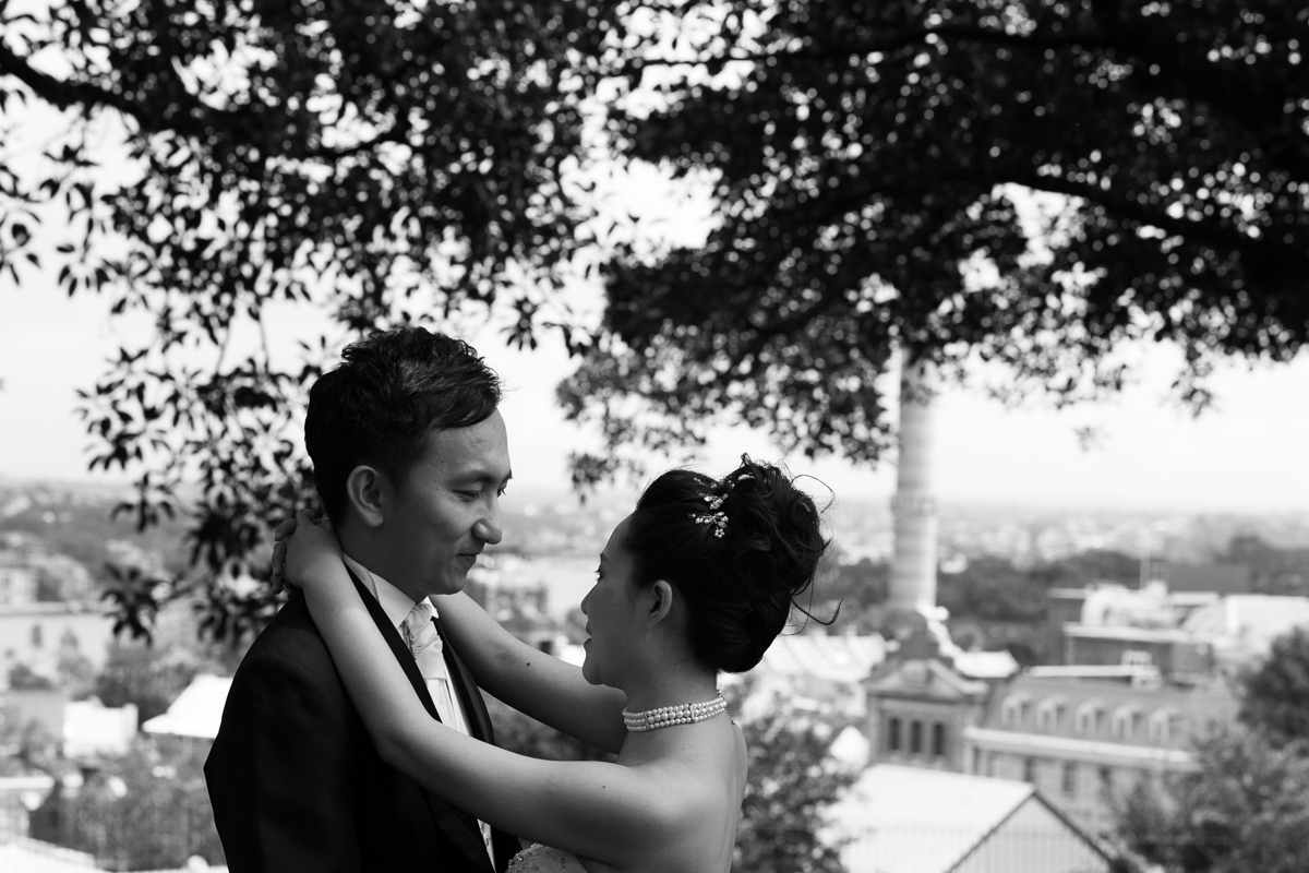 Black and white shot of the bride and groom gazing into each others eyes with the cityscape of Sydney in the background Sydney wedding photographer