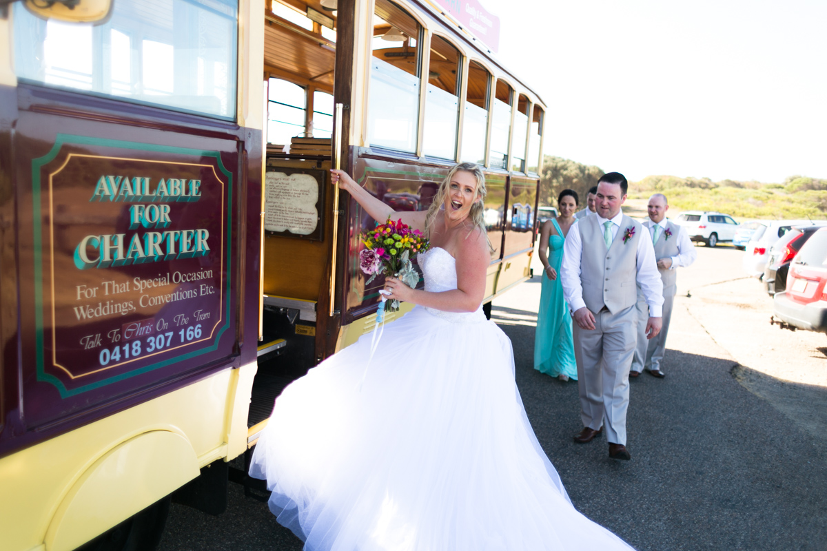 Candid shot of the bride climbing on the Newcastle's Famous Tram Caves Beach wedding photography