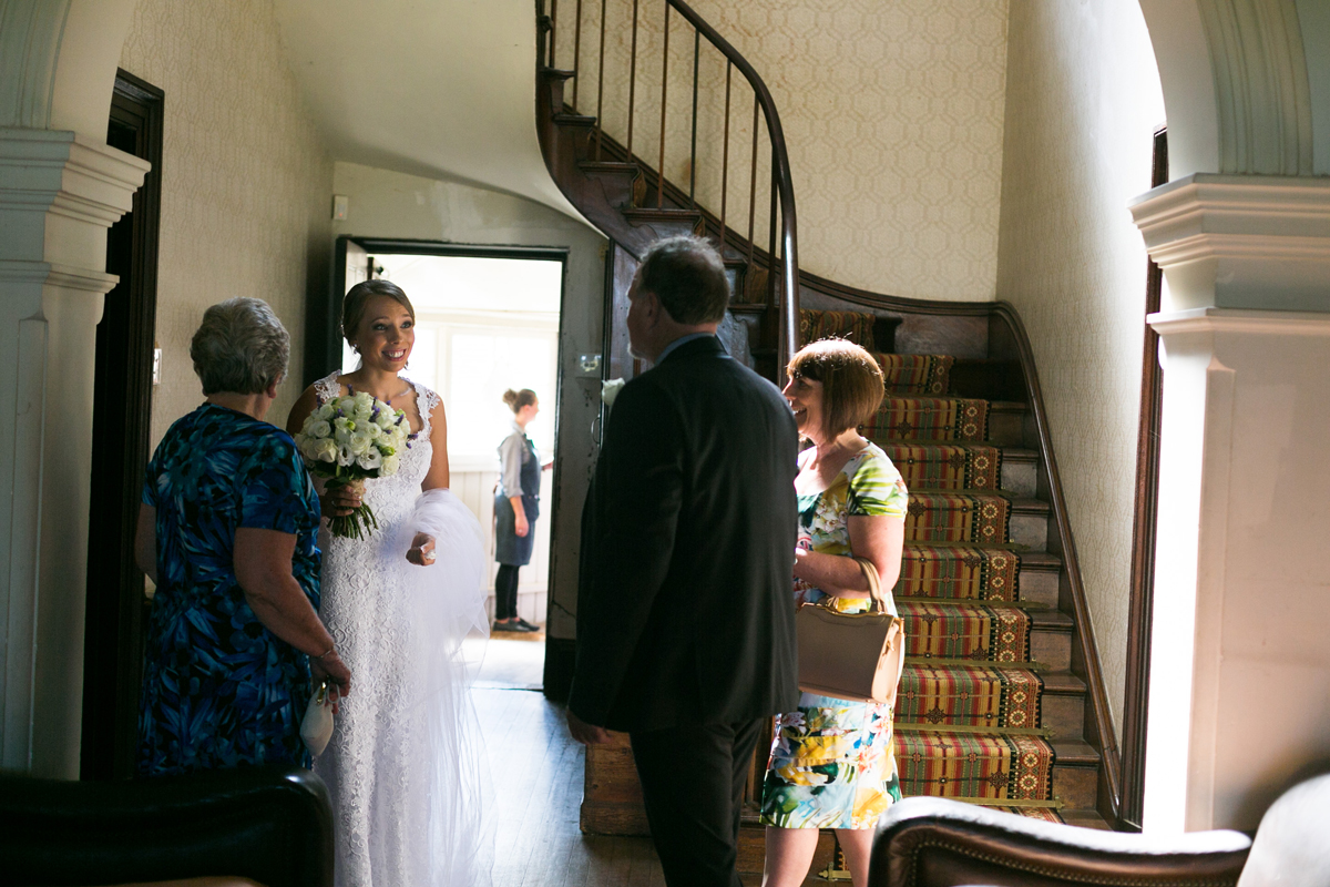 Candid shot of the bride nervously talking to her family inside the Tocal Homestead at the bottom of the stairs before walking down the aisle at her Tocal Homestead wedding photographer
